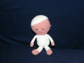 Muñeco de crochet con pijama y gorro blancos