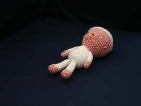 Muñeco de crochet con pijama y gorro blancos